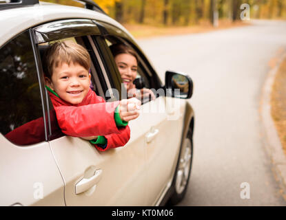 Sonriente niño mirando a través de la ventana de coche