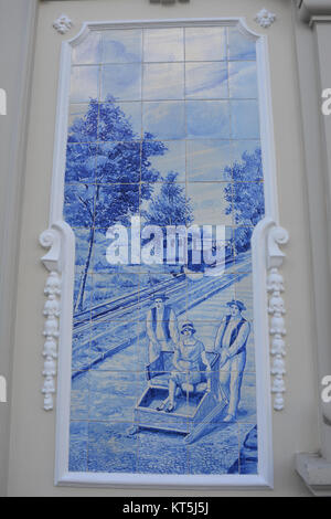 El famoso tobogán de mimbre trineo ilustrados en azul de los azulejos pintados a mano, o azulejos, en la fachada del Hotel Ritz, Funchal, Madeira, Portugal Foto de stock