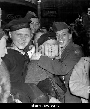 Celebración del Día V-E en Piccadilly Circus, Londres, 7 de mayo de 1945. Una jubilosa soldado americano abraza una mujer inglesa maternal celebrando la rendición incondicional de Alemania. Guerra Mundial 2. (BSLOC 2014 8 105). Foto de stock