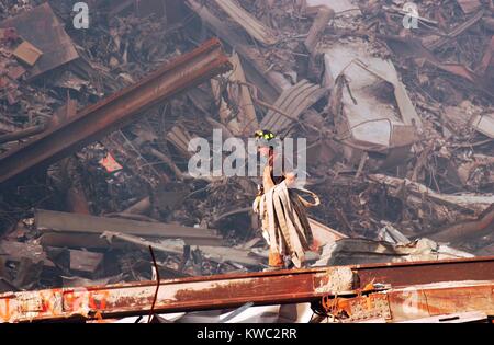 NYC fire fighter lleva una manguera contra incendios más incendios lentos y restos en el Ground Zero, 18 de septiembre de 2001. World Trade Center, en Nueva York, después del 11 de septiembre de 2001 ataques terroristas. (BSLOC 2015 2 97) Foto de stock
