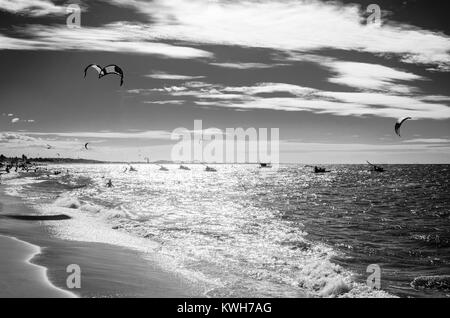 Puesta de sol en blanco y negro con kite surf disfrutando del mar al atardecer Foto de stock