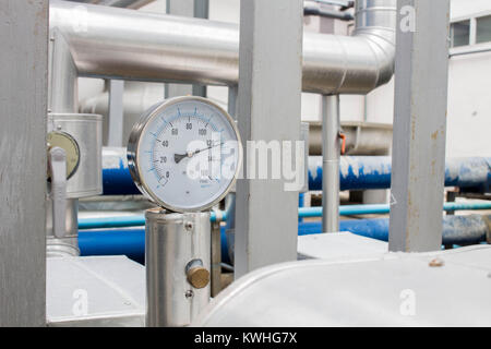 El manómetro y termómetro en agua fría en la tubería del sistema