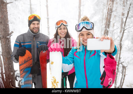 Jóvenes varones y mujeres snowboarders teniendo selfie juntos Foto de stock