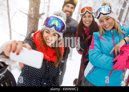 Teniendo selfie hembra con amigos en vacaciones de invierno en la naturaleza Foto de stock