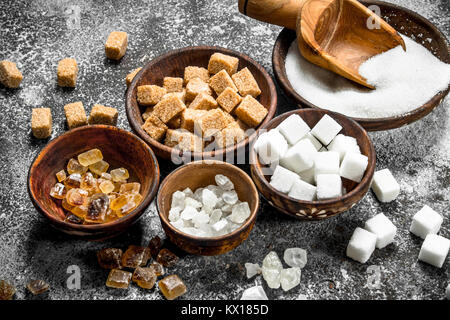 Los diferentes tipos de azúcar en tazones. Sobre un fondo rústico. Foto de stock