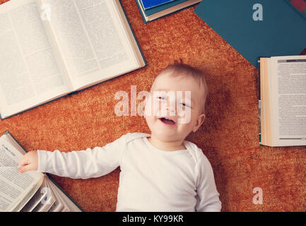 Bebé de Un año de edad con spectackles y libros