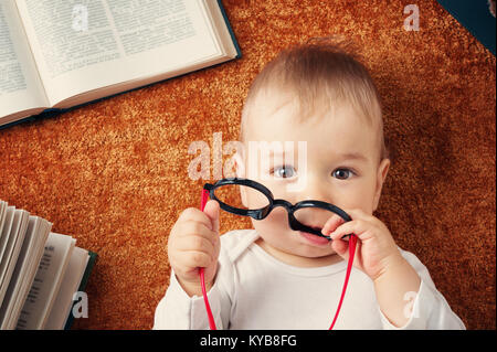 Bebé de Un año de edad con spectackles y libros