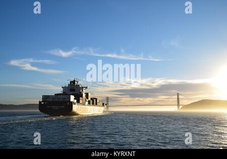 Buque portacontenedores NYK Constelación sale de San Francisco Bay bajo el puente Golden Gate en el atardecer.
