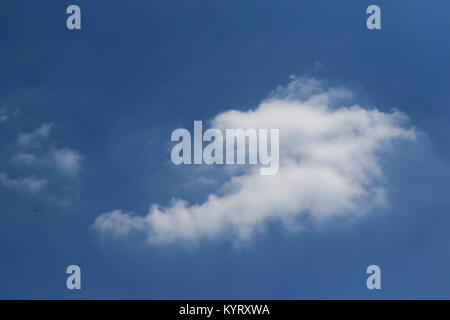 Antecedentes de uso - mullida nube blanca contra un cielo azul claro con las golondrinas volando, imagen en formato horizontal con espacio de copia Foto de stock