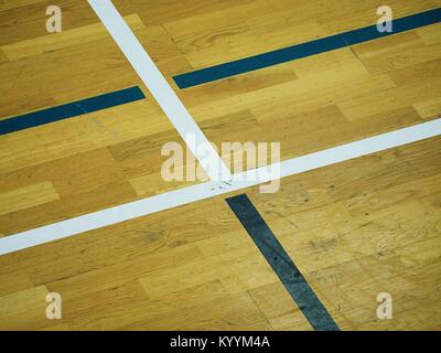 Vista de cerca del piso de madera Cancha de baloncesto. Sala deportiva con fuertes rayos, sratches en la pintura transparente