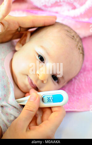 Bebé recién nacido hijo de gripe fiebre termómetro de medida de temperatura Foto de stock