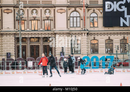 Helsinki, Finlandia - 11 de diciembre de 2016: Jóvenes y Niños patinando sobre hielo en la Plaza del Ferrocarril en el día de invierno.