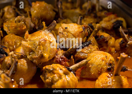 Las patas de pollo en salsa, al horno en el asador Foto de stock