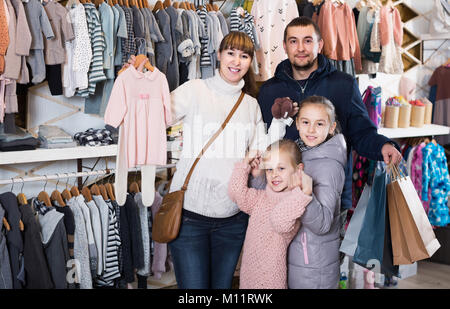 Madre e hija en la tienda de ropa para niños, telefoto
