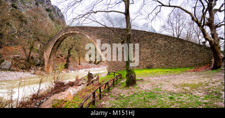 Puente de arcos de piedra Pyli en un día lluvioso, Tesalia, Grecia Foto de stock