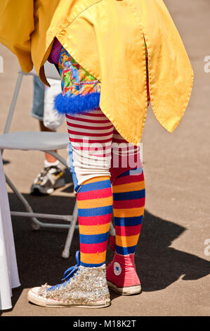 Vista trasera de un payaso con coloridos calcetines en una chaqueta amarilla Fotografía de stock Alamy
