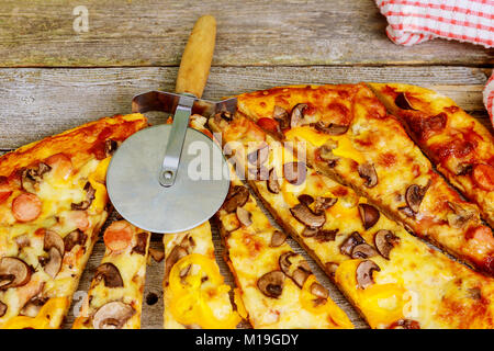 Flatlay. Close-up de rebanadas de pizza de pepperoni de tablero de madera. Mesa servida con comer comida rápida en la cafetería. Pizza en rodajas sobre la mesa Foto de stock