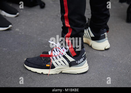 Milán - 15 de enero: hombre con blanco y negro zapatos Nike Air y pantalón negro con raya antes de representar el Fashion Show, la Semana de la moda de