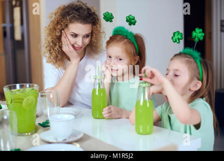 Mujer con niños celebrando el Día de San Patricio en casa Foto de stock