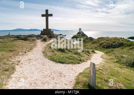 Una gran cruz de madera y Tŵr Mawr faro en la isla Llanddwyn en un soleado día de finales de verano, Anglesey, Gales