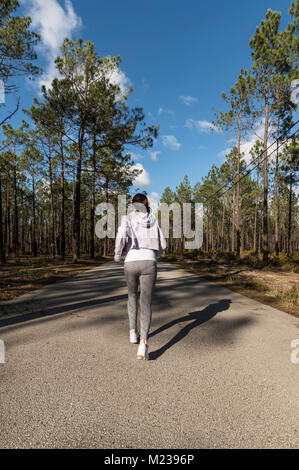 mujer corriendo en un camino de campo a través del hermoso bosque soleado,  el ejercicio y el concepto de fitness Fotografía de stock - Alamy