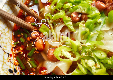 Sopa de fideos picantes con verduras, hierbas, maní y cilantro, popular en la provincia de Yunnan, profundidad de campo, China.