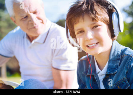 Retrato de niño en auriculares sonriendo a la cámara Foto de stock