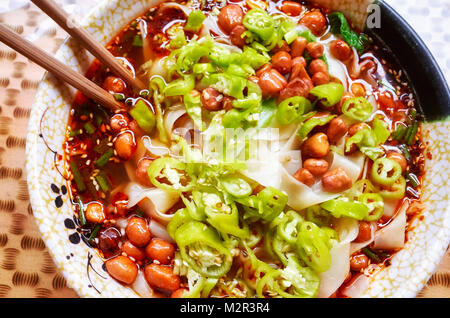 Sopa de fideos picantes con verduras, hierbas, maní y cilantro, popular en la provincia de Yunnan, profundidad de campo, China.