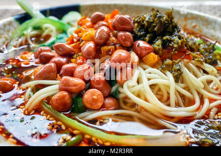 Sopa de fideos picantes con verduras, hierbas, maní y cilantro, popular en la provincia de Yunnan, profundidad de campo, China.