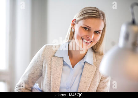 Retrato de joven empresaria sonriendo en la oficina Foto de stock