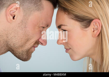 Close-up de pareja joven busca airadamente a uno y otro Foto de stock