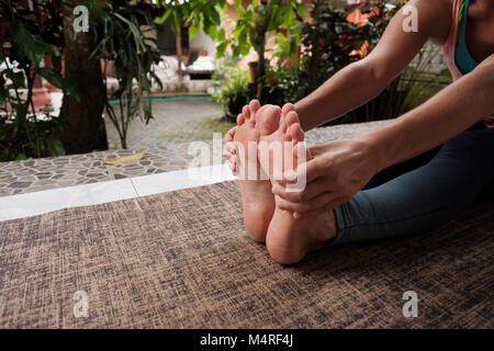 Detalle de la mujer caucásica haciendo ejercicios de yoga asana. Chica sentado adelante doblar pose. Estilo de vida saludable fuera Foto de stock