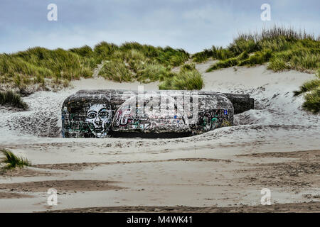 Restos de un bunker de WW2 con graffiti en una playa francesa Foto de stock