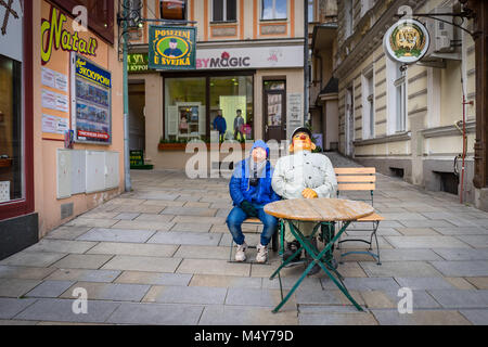 Praga, República Checa - Marzo 4, 2016: Asia muchacho sentado junto a doll en Karlovy Vary, República Checa el 4 de marzo de 2016