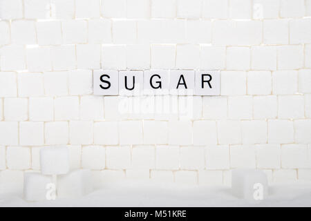 Muro de terrones de azúcar con azúcar word enunció algunos de los ladrillos. El azúcar ofrece "calorías vacías" calorías acompañados de fibra, vitaminas, mín. Foto de stock