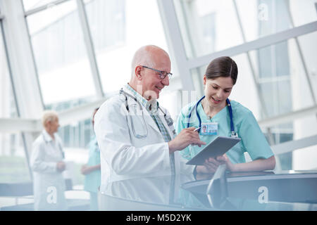 Un médico y una enfermera con tableta digital hablando en el hospital Foto de stock