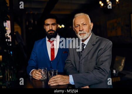 Retrato de dos hombres en un elegante bar con vasos