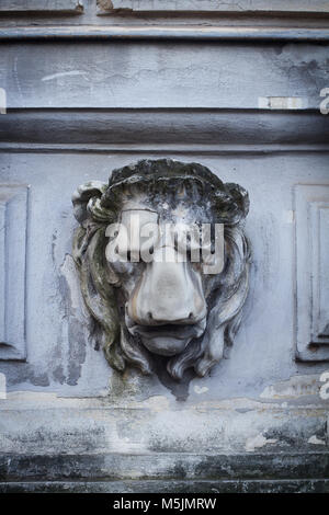 Vista frontal closeup de escultura de cabeza de león tallada en piedra en el exterior de un edificio histórico