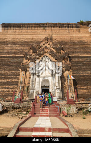 Pocas personas en frente de las ruinas del monumento inacabado Mingun Pahtodawgyi stupa en Mingun, cerca de Mandalay en Myanmar en un día soleado. Foto de stock
