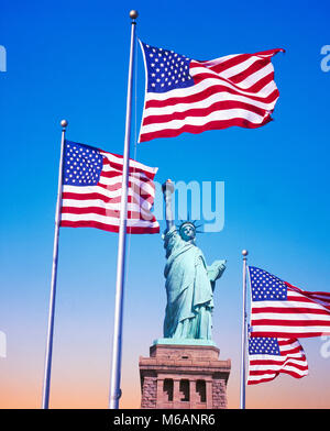 La estatua de la libertad y el Stars & Stripes banderas,Liberty Island, Nueva York, EE.UU. Foto de stock