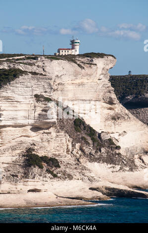 Córcega: los impresionantes acantilados de piedra caliza blanca en el International Bouches de Bonifacio parque marino con vista del Faro de Cabo Pertusato Foto de stock