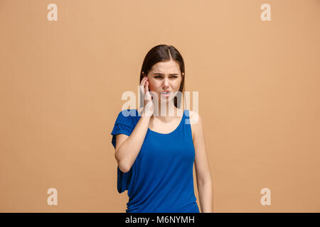 El dolor de oído. La triste mujer con dolor de cabeza o dolor en un pastel de fondo de estudio. Foto de stock