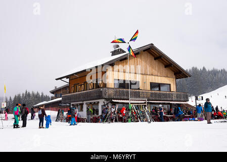Le Yeti Snack bar en las pistas de esquí en Les Gets cerca de Morzine con esquiadores y un colorido Windmill Haute Savoie Portes du Soleil Francia Foto de stock