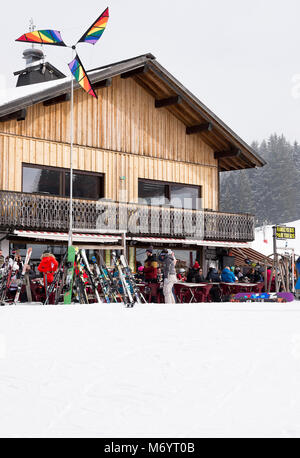 Le Yeti Snack bar en las pistas de esquí en Les Gets cerca de Morzine con esquiadores y un colorido Windmill Haute Savoie Portes du Soleil Francia Foto de stock