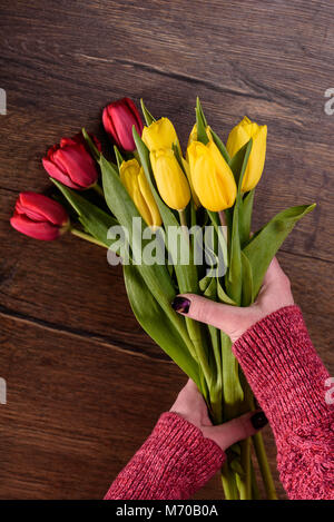 Floristería hace un Ramo de tulipanes rojos y amarillos. Cerrar Foto de stock