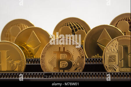 En una placa base de las ranuras son monedas de oro permanente de monedas - criptografía digital bitcoin litecoin rizado. Foto de stock
