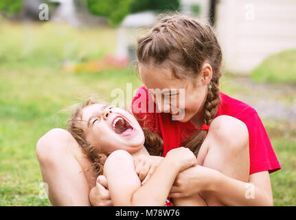 Dos niñas feliz abrazando y riendo en el parque