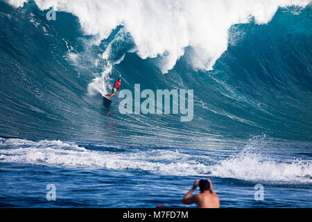 Un tow-in surfer desciende el rostro de Hawaii's big surf en Peahi (Jaws) Maui, Hawaii.