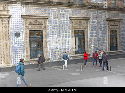Los peatones hacen su camino a lo largo de la Calle de Consdesa junto a la famosa Casa de los azulejos azules en la Ciudad de México, México. Foto de stock