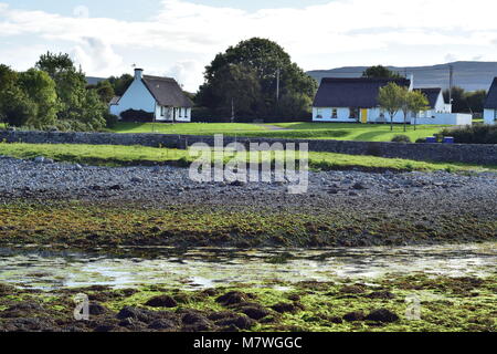 Chaletes blanco con techo de paja, en la aldea de Ballyvaughan en la costa oeste de Irlanda.